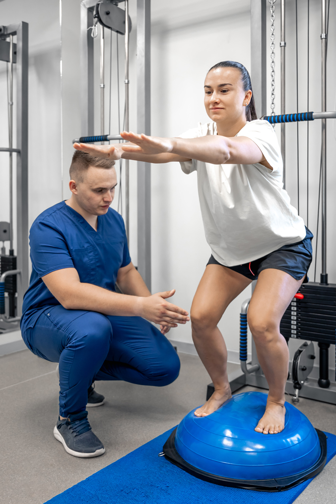 Balance exercise with bosu ball, woman and doctor in gym.